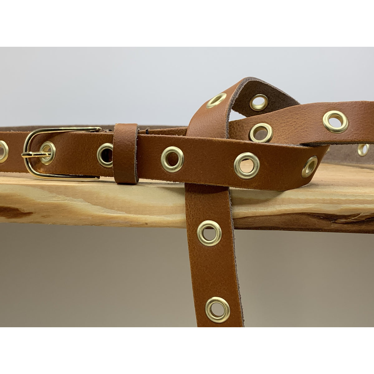 Lange trendy cognac knoopriem met gouden ringen