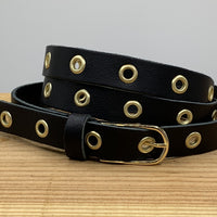 Lange trendy zwarte knoopriem met gouden ringen.