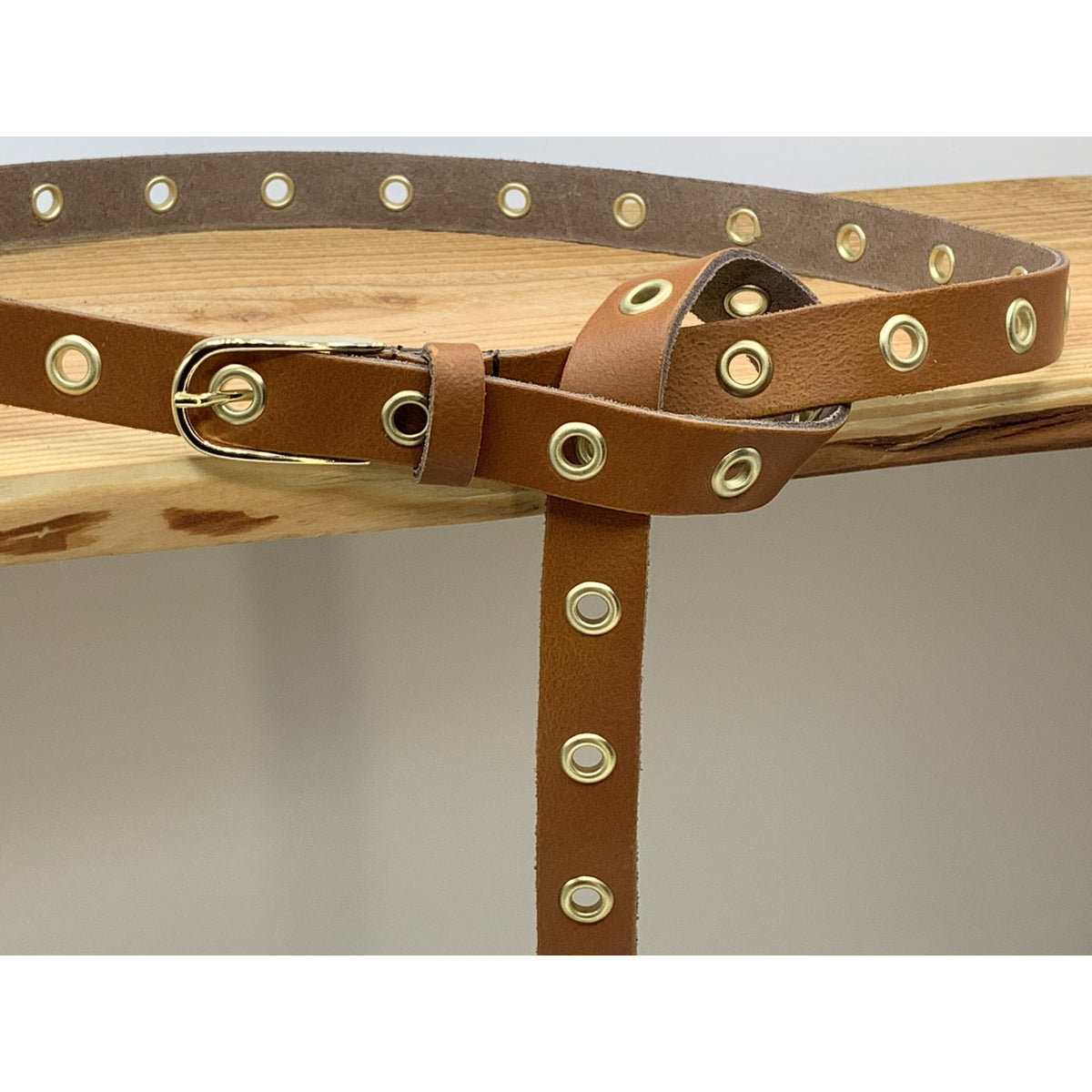 Lange trendy cognac knoopriem met gouden ringen