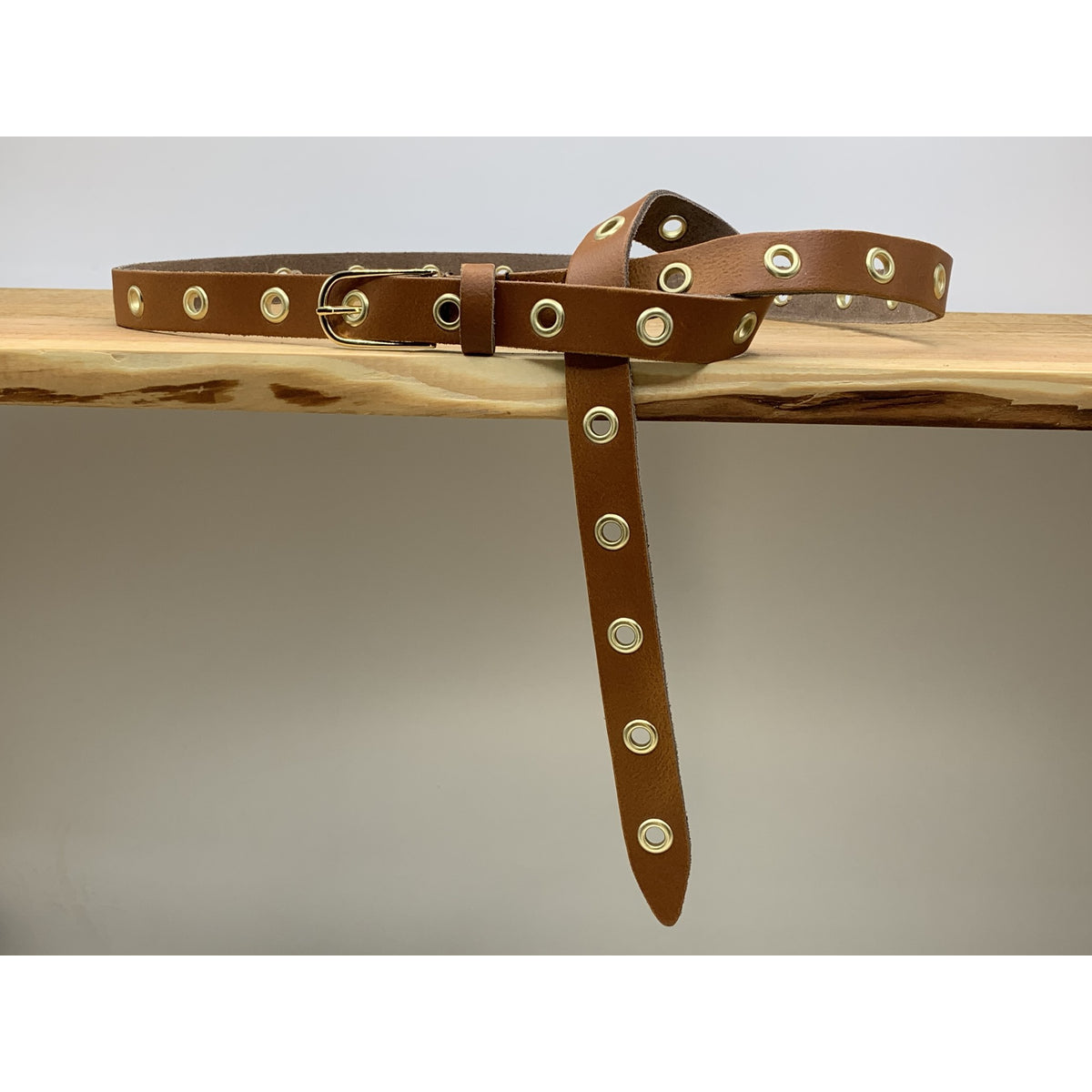 Lange trendy cognac knoopriem met gouden ringen