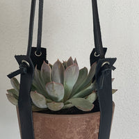 Terracotta kleurige hangpot small met echt lederen banden.