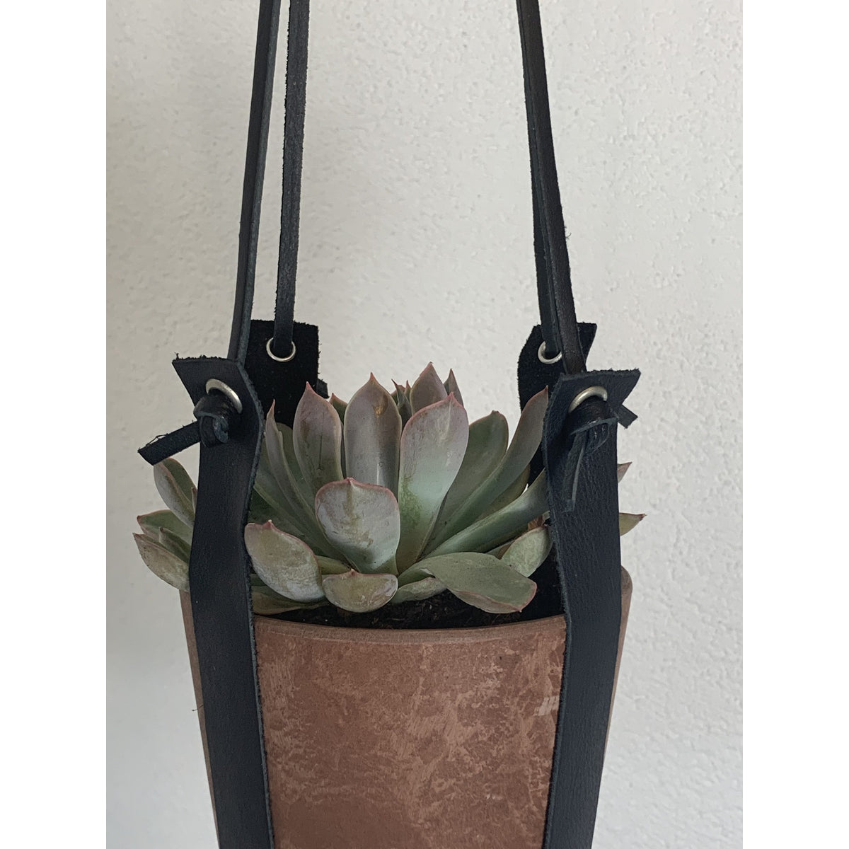 Terracotta kleurige hangpot small met echt lederen banden.