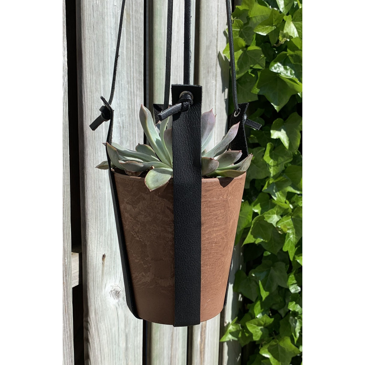 Terracotta kleurige hangpot small met echt lederen banden.