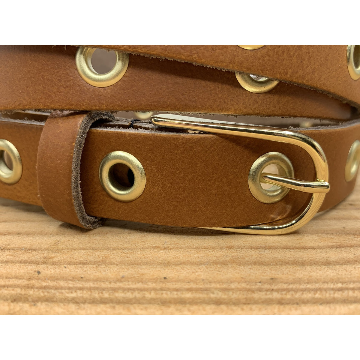Lange trendy cognac knoopriem met gouden ringen
