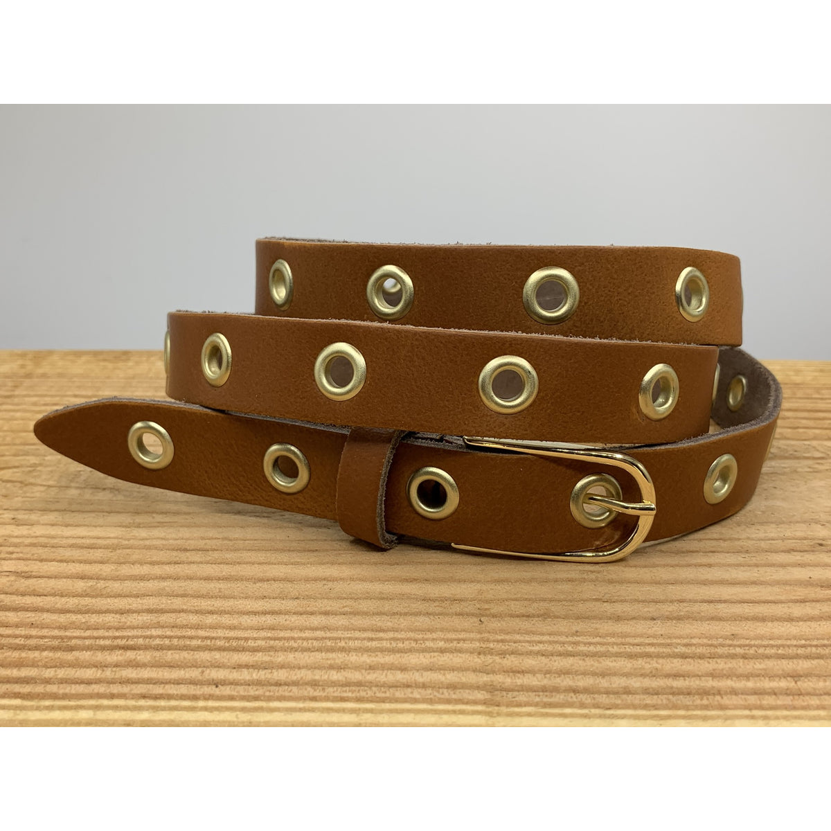 Lange trendy cognac knoopriem met gouden ringen