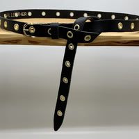 Lange trendy zwarte knoopriem met gouden ringen.