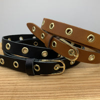Lange trendy zwarte knoopriem met gouden ringen.