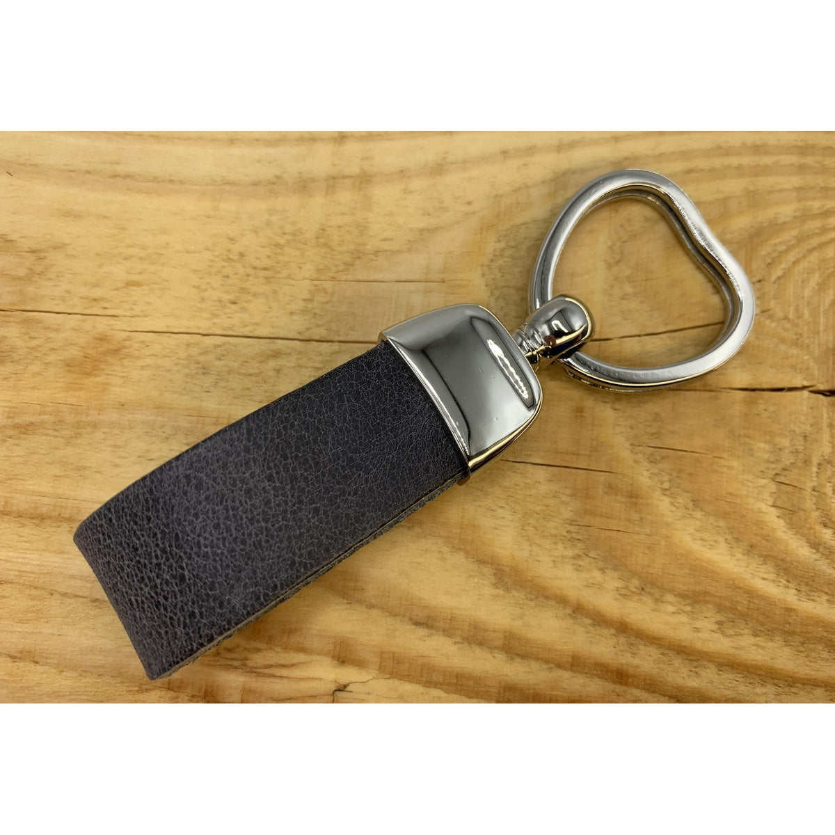 Grijze sleutelhanger met hart vormige sleutelring.