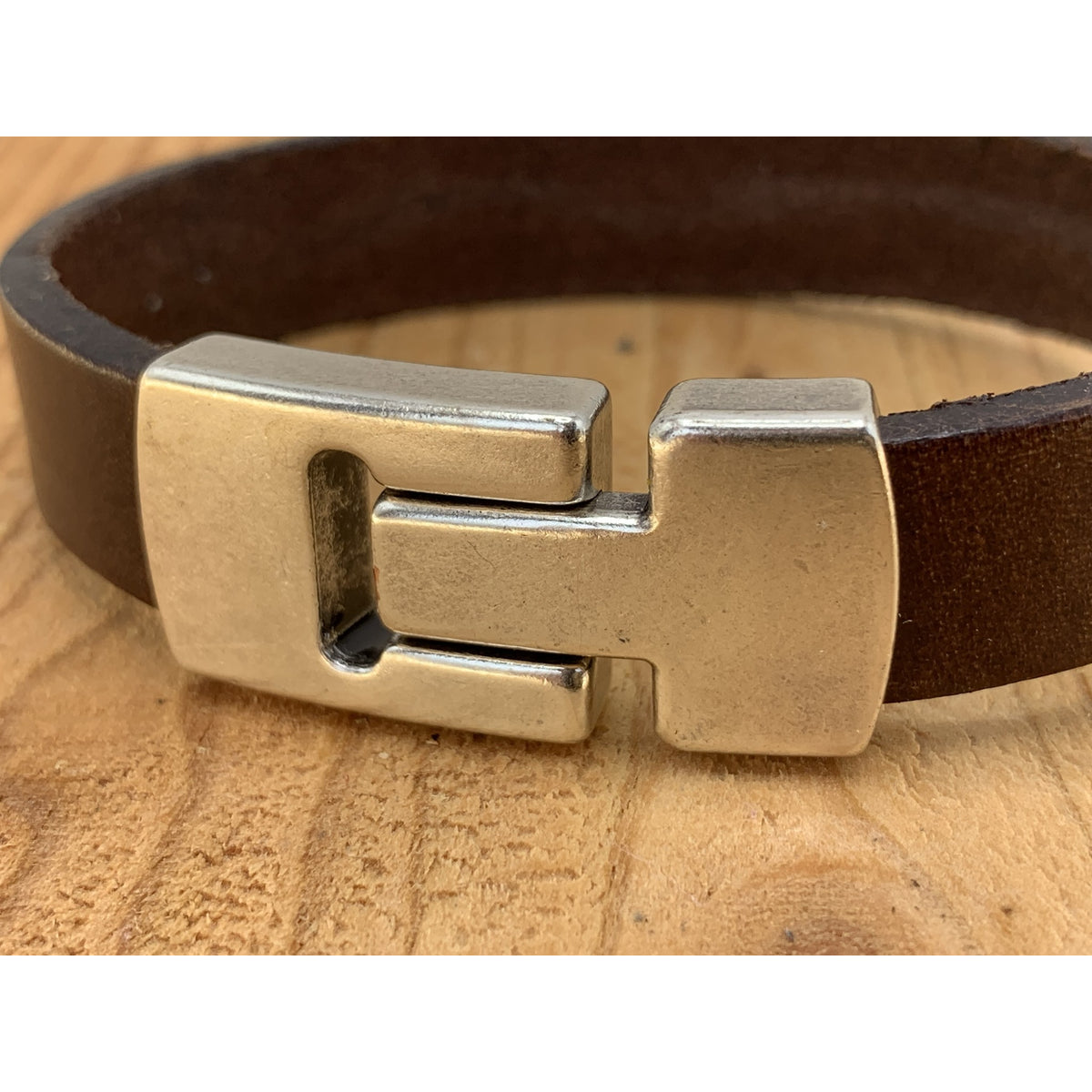Bruine armband met wax randen voor een perfecte afwerking.