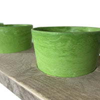 Kruidenrek met groene potjes.