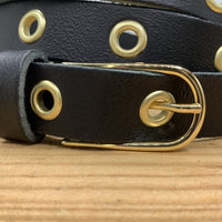 Lange trendy zwarte knoopriem met gouden ringen.